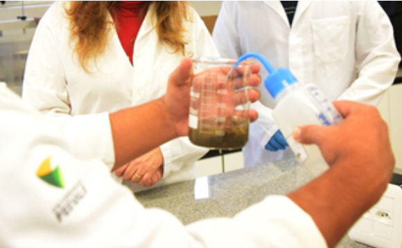 Cientista enxendo um becker
