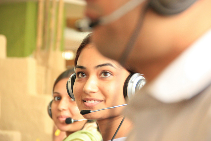 Homem em call center, atendendo cliente com um headset pequeno