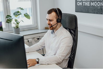 Homem em call center, atendendo cliente com um headset pequeno